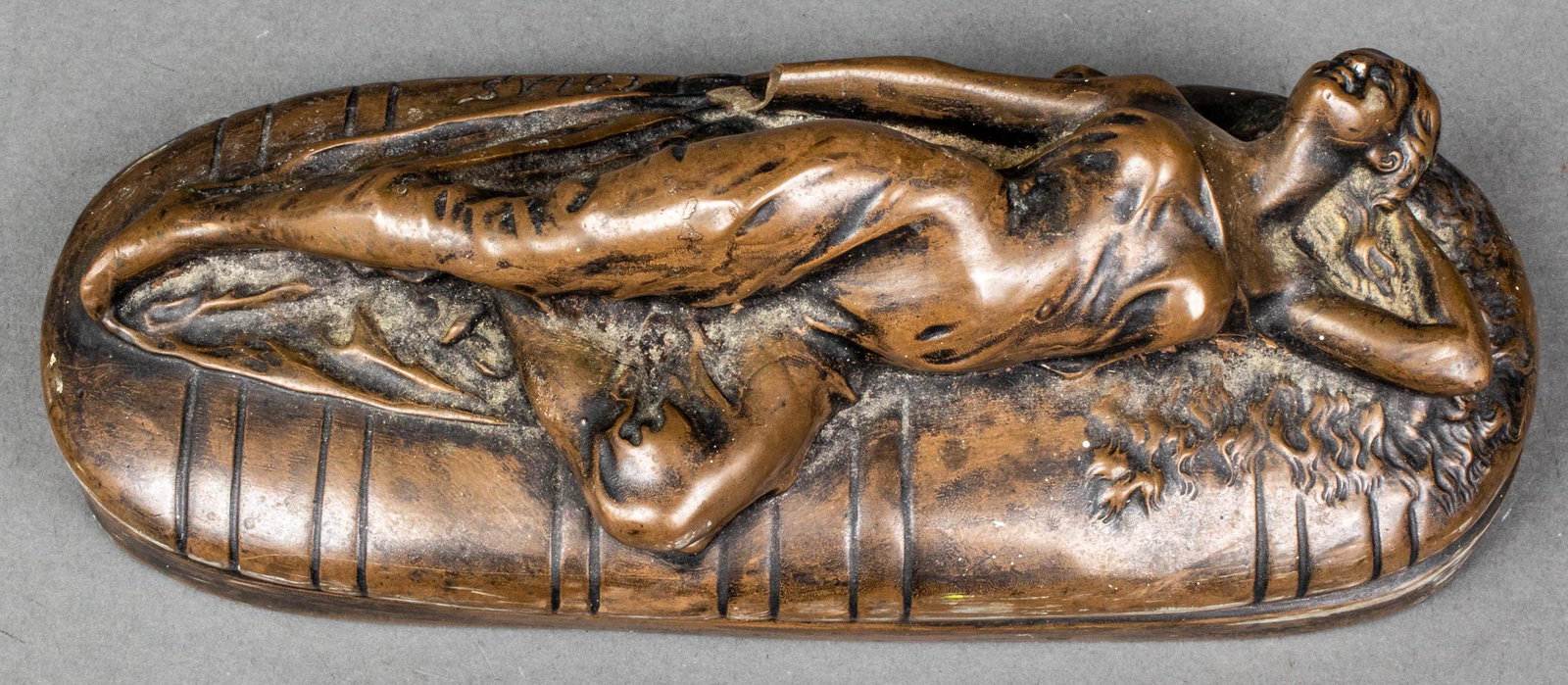 Poullain Colas Bronze Model Of A Reclining Woman: Bronze model of a reclining woman, depicted lying contrapposto in a moment of rest across a striped divan, base signed "Poullain" and "Colas". 2.75” H x 9” W x 3.75” D. Provenance: F