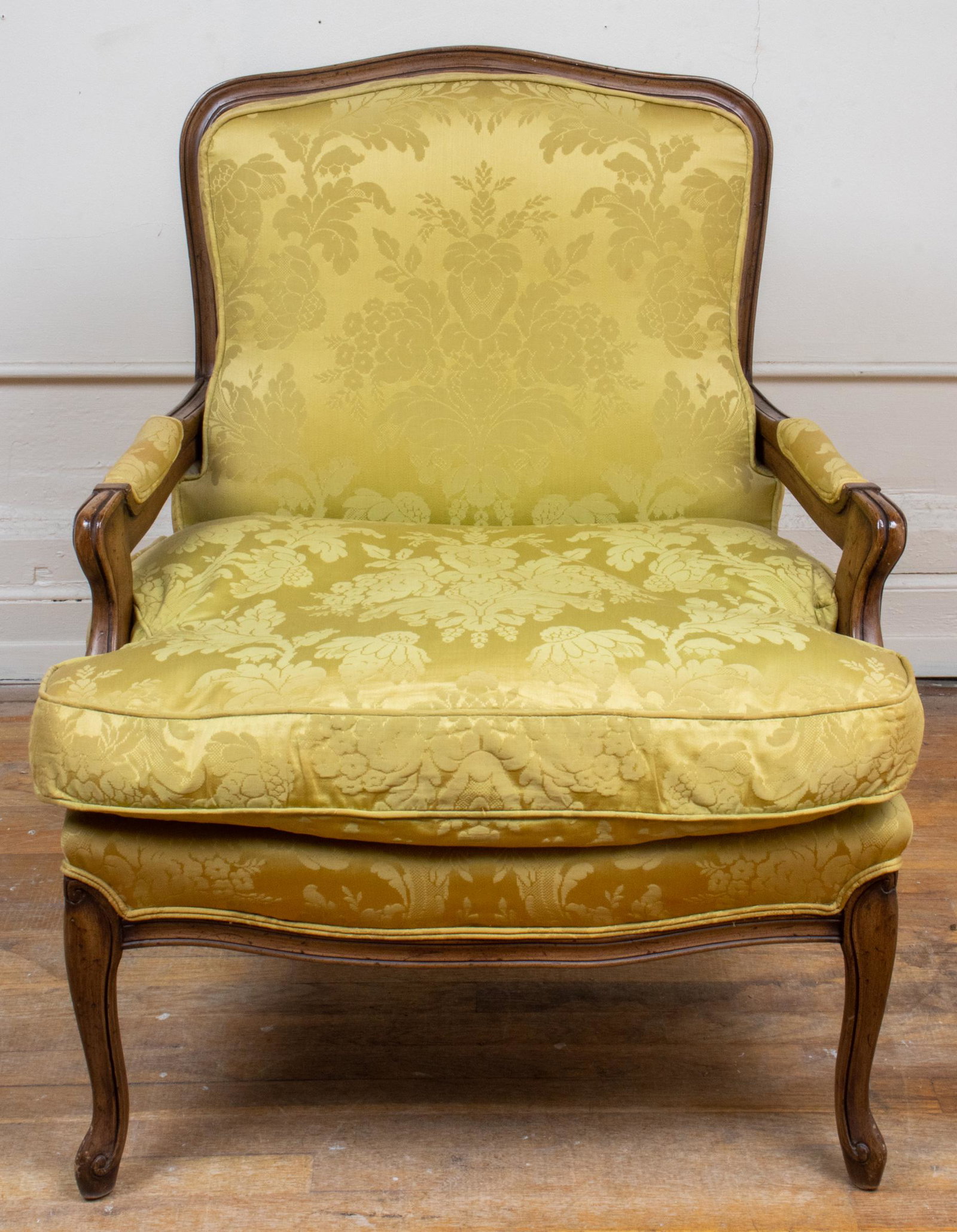 Louis XV Style Fauteuil à la Reine: Louis XV style fauteuil à la reine, the frame carved with reeded grooves and upholstered with yellow damask pattern fabric, raised on cabriole legs. 34” H x 28” W x 26.5” D
