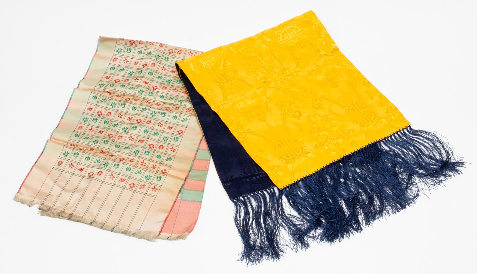 Silk Scarves, 2 Pcs.: Gold and blue rectangle with fringe and draw string storage bag features an Asian design motif 53" L x 13" D and a cream colored rectangle with a floral and linear design. 47.5" L x 12" D. Marks and f