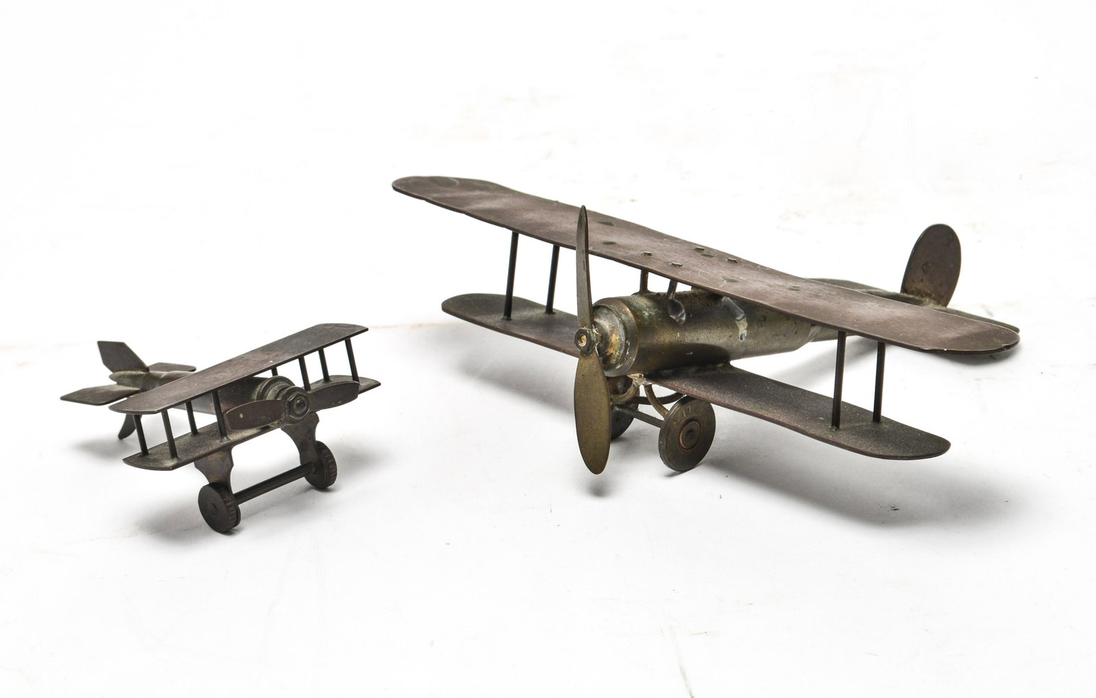 Metal Airplane Sculptures from Bullet Casings, 2: Two metal airplane sculptures with bodies made from bullet shell casings. 2.25" H x 8" W x 6.25" D.