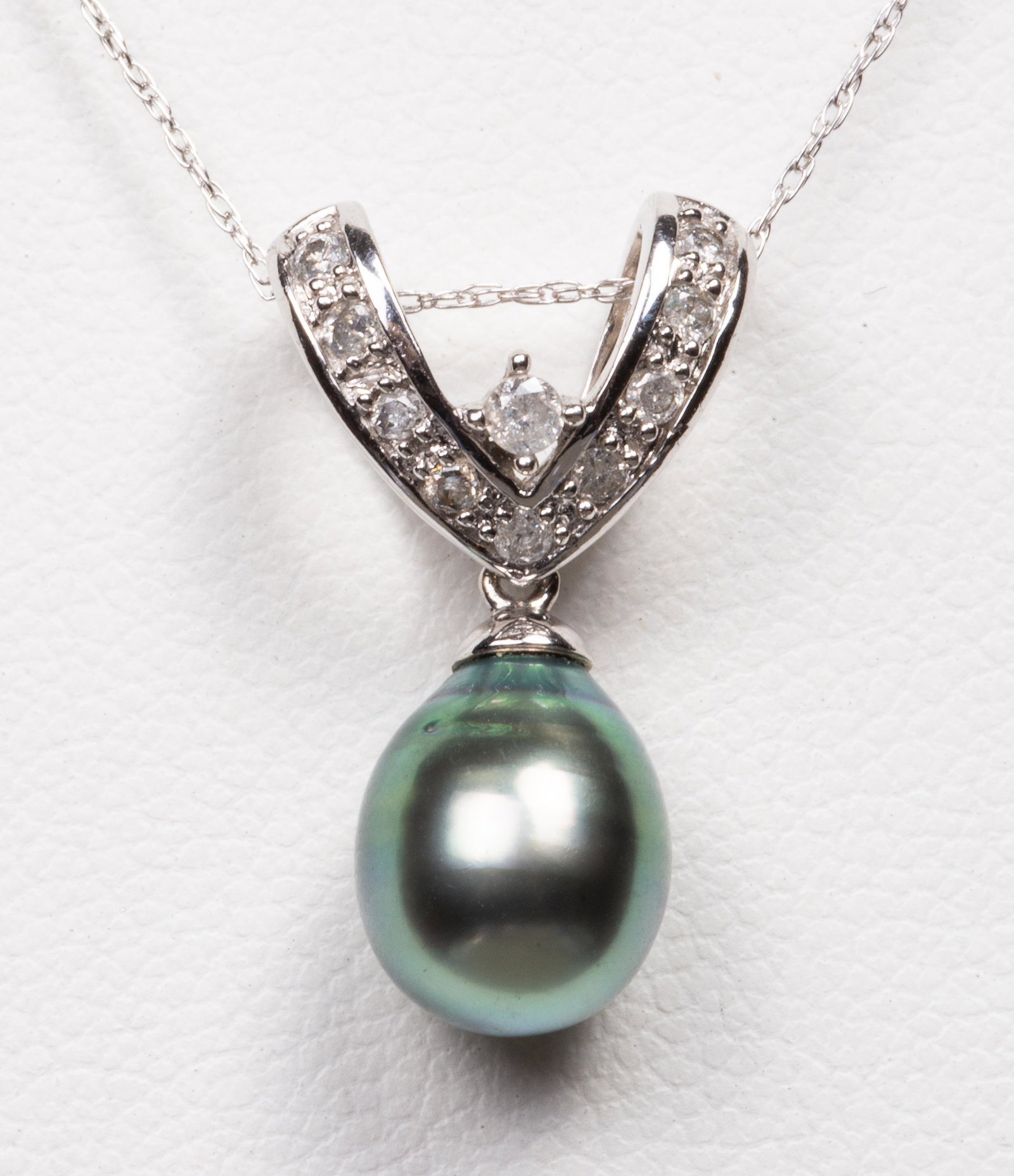 14K Tahitian Pearl & Diamond Pendant Necklace: 14K white gold, Tahitian pearl and diamond pendant necklace, one 10 mm x 8 mm Tahitian pearl with very good luster and greenish-pink undertones and ten round brilliant-cut diamonds; approx: 0.17 ct tw