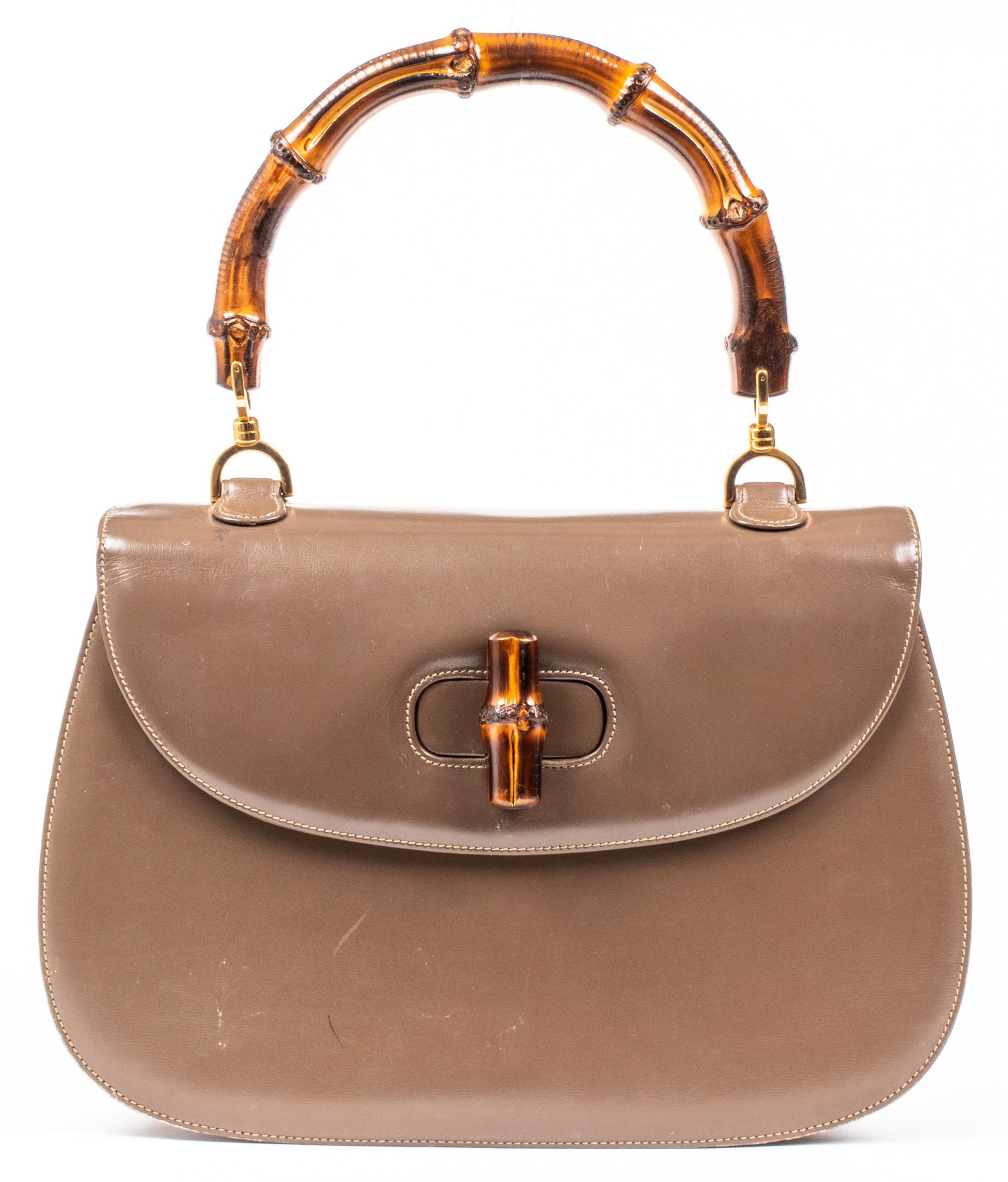 Gucci Brown Leather Bamboo Handle Handbag: Gucci brown leather bamboo handle handbag with gold-tone hardware and rotating bamboo clasp, the interior with three pockets and convertible shoulder strap, with "Gucci" tab and serial number to rever