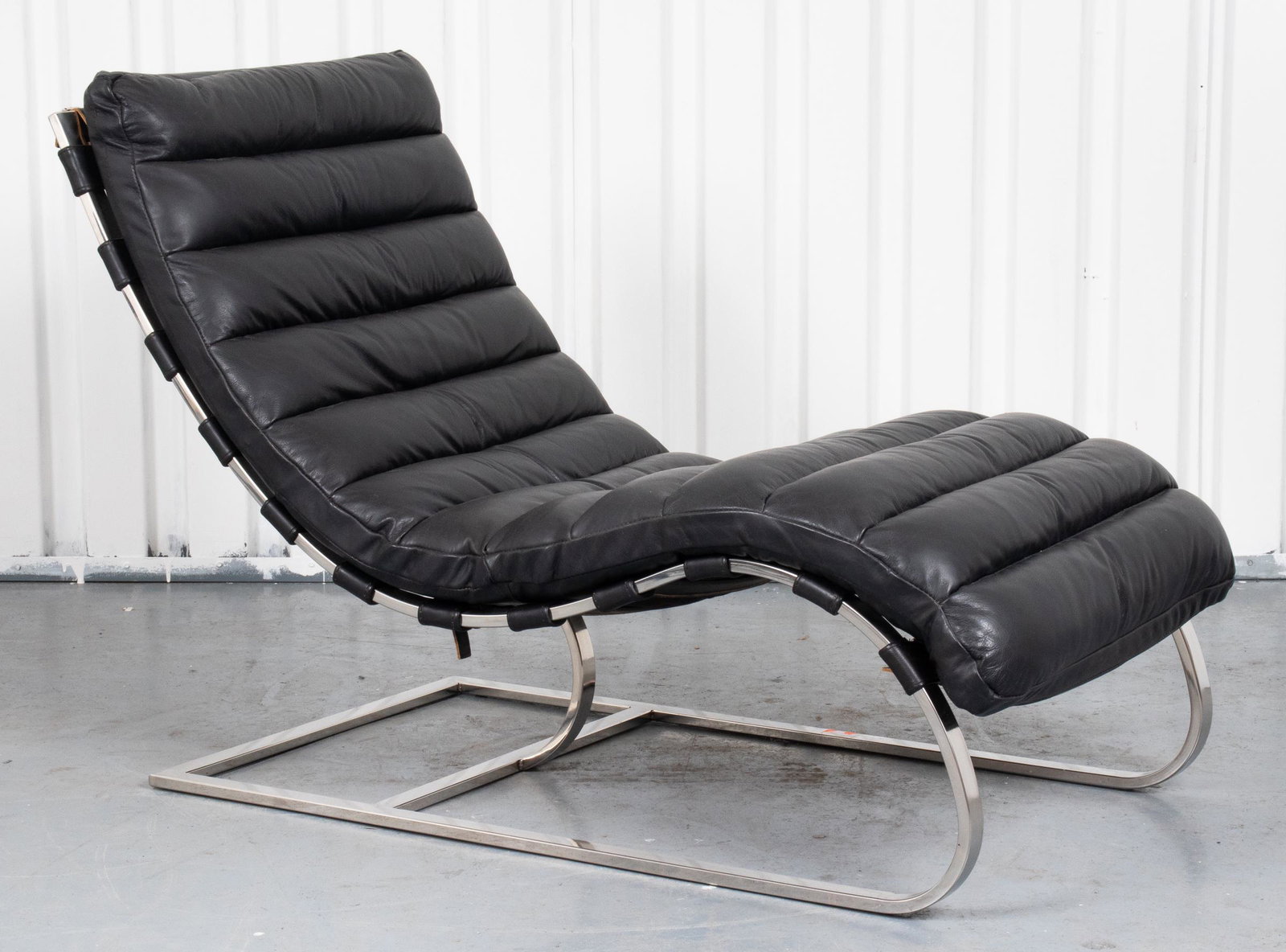 Mid-Century Style Oviedo Leather And Steel Chaise: Oviedo chaise by Restoration Hardware, in the mid-century taste and of undulating outline, the channel stitched black leather seat strapped on the cantilever steel base. 32” H x 24” W x 49” D. P