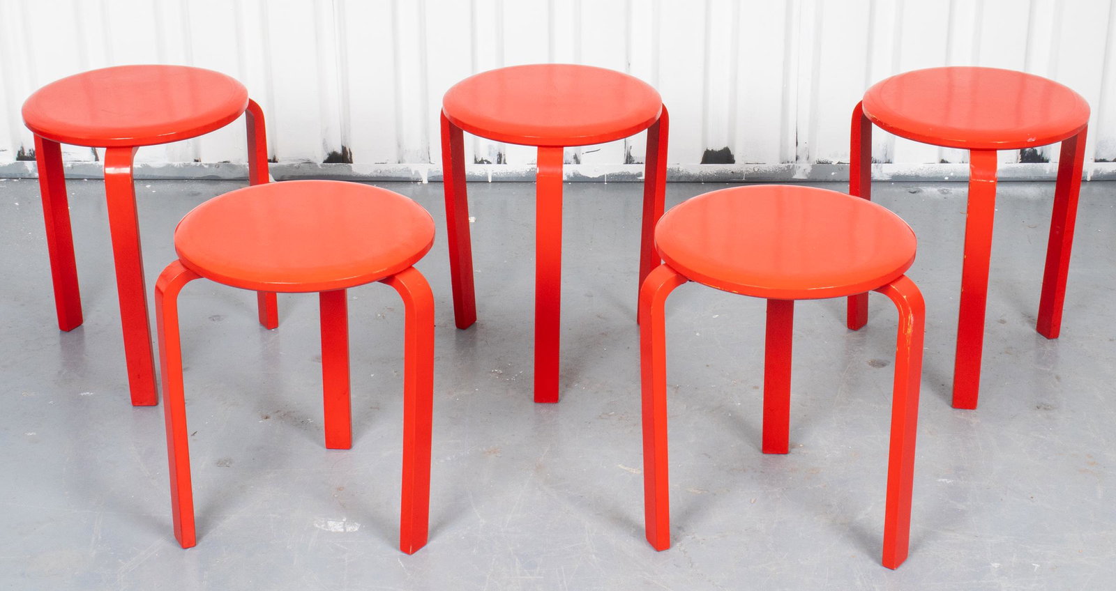 Alvar Aalto Mid-Century Modern Stacking Stools, 5: Alvar Aalto mid-century modern red lacquered stacking stools, set of five, stamped underside: "Made in Sweden." 17.5" H x 13.75" diameter. Scattered losses to finish, one with split to underside.