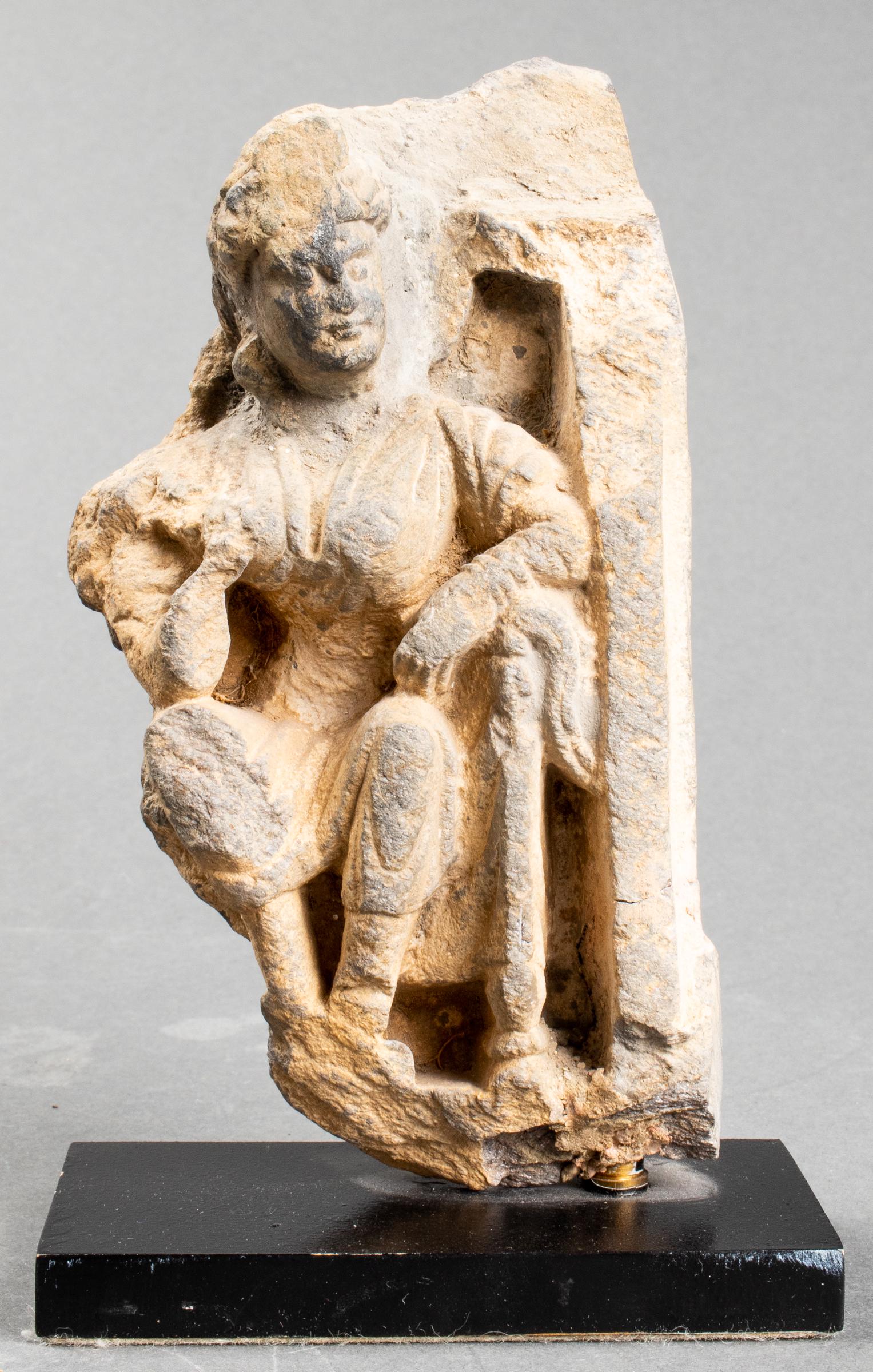 Gandhara Figural Carved Stone Fragment: Gandhara carved schist architectural fragment of a figure, mounted to base. Stone: Provenance: Removed from a private residence at the Pierre Hotel. 6.75" H x 3.25" W x 2" D.