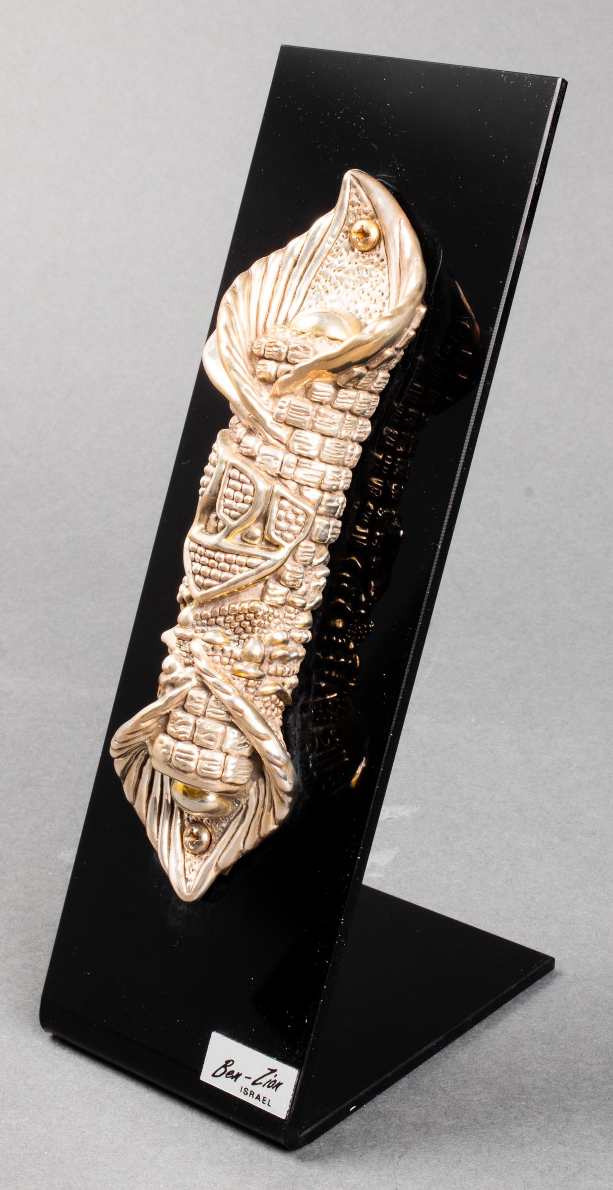 Ben-Zion Israel Judaica Sterling Silver Mezuzah: Ben-Zion Israel Judaica sterling silver mezuzah mounted on black acrylic stand, bearing maker's mark and "925" to lower edge, the stand with label: "Ben-Zion Israel." Overall: 8.5" H x 3" W x 4" D. Si