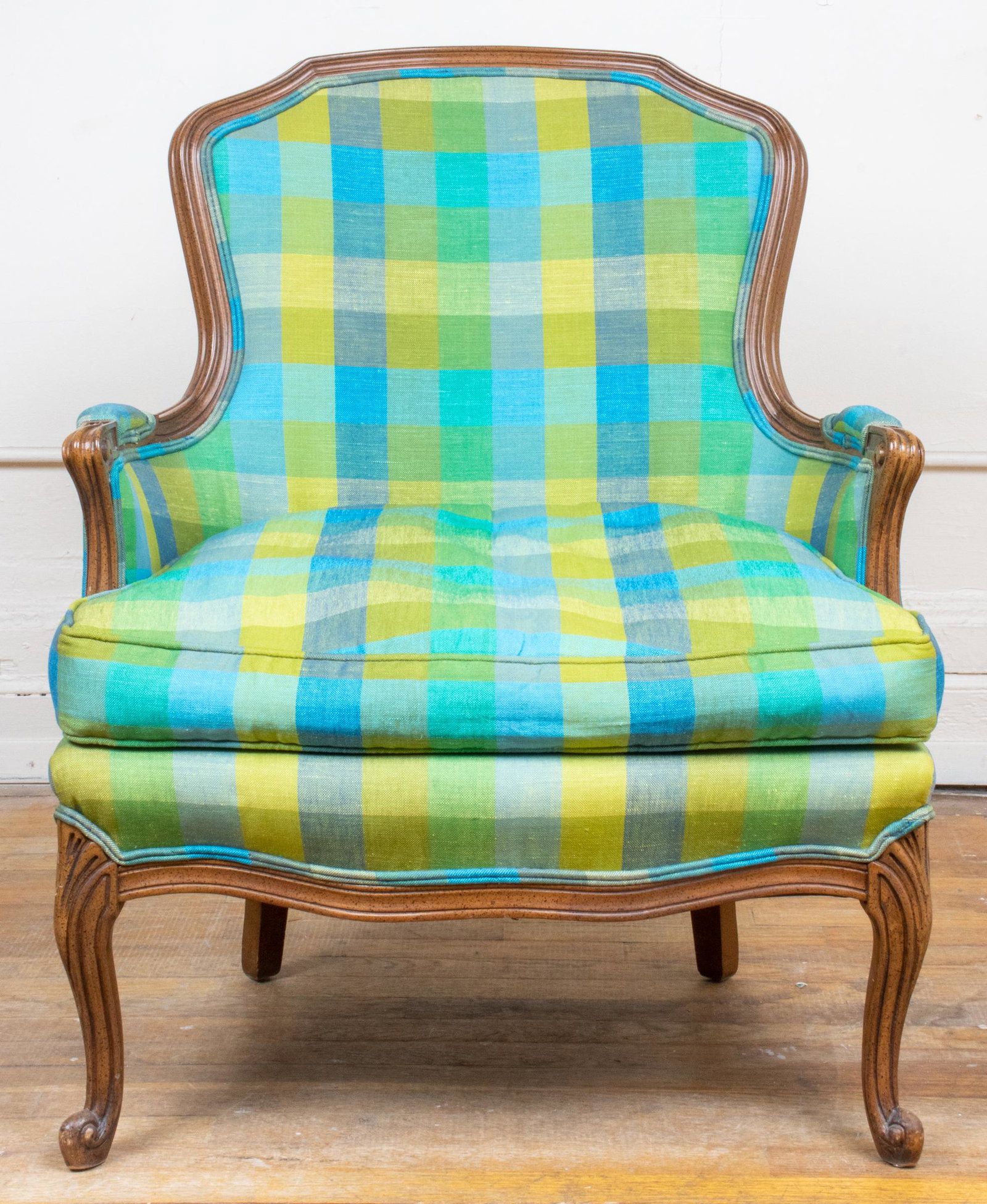 Louis XV Style Plaid Upholstered Bergere: Louis XV style fruitwood bergère, the carved frame with plaid upholstered back and wide seat. 35.5” H x 28.75” W x 27.5” D