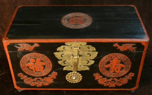 Antique Painted Korean Wedding Chest: Traditional footed wedding chest painted black with red outline with an ornamental brass lockplate in the shape of a lotus flower, brass hinges, and two brass handles. Symbols for good fortune and lon