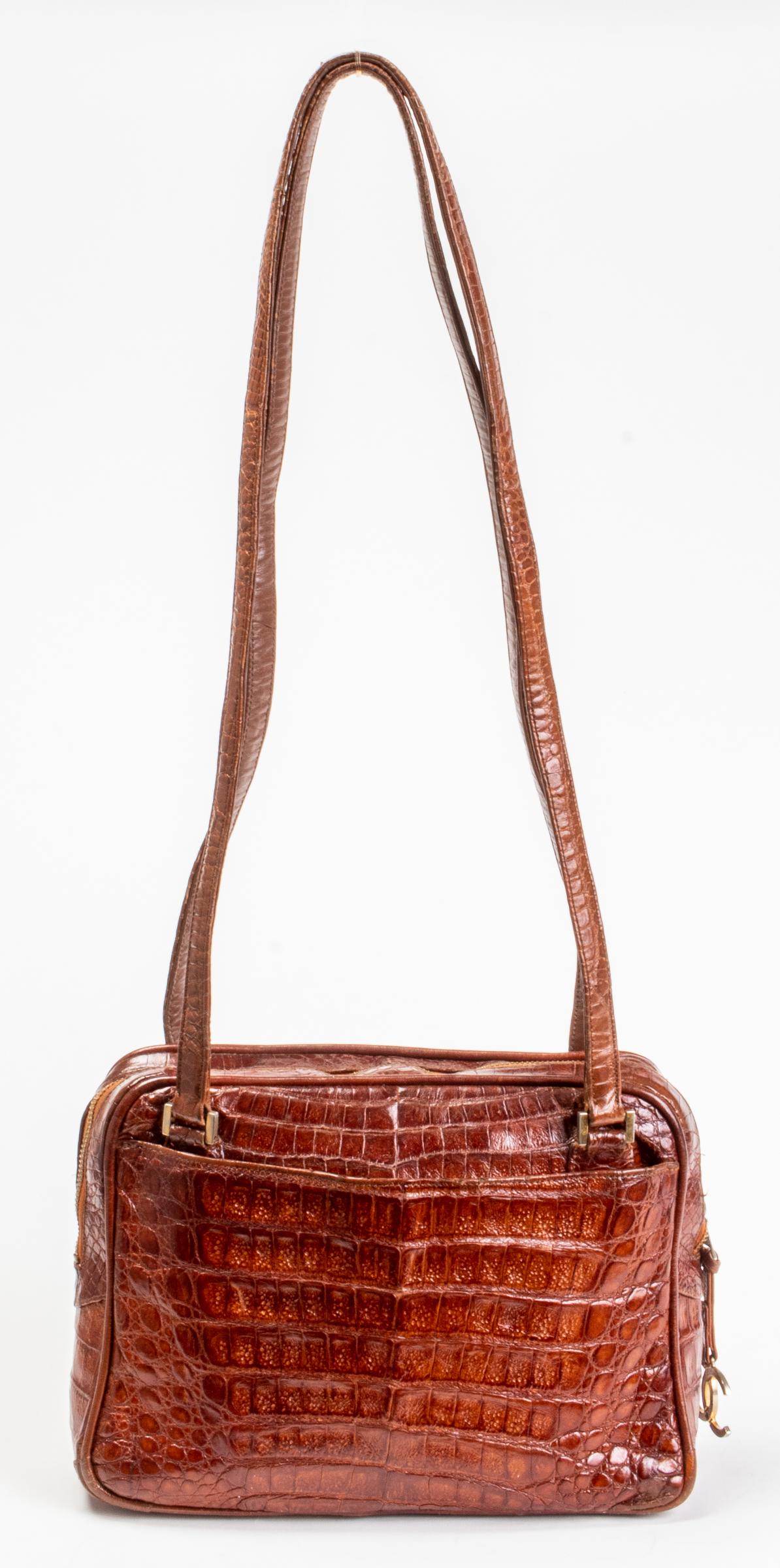 Chanel Brown Crocodile Handbag: Chanel brown crocodile handbag, circa 1980, with gold-tone hardware and double handles, exterior with two pockets, interior with two pockets and with tab stamped "CHANEL®." 7.5" H x 11" W x 3.75" D. 
