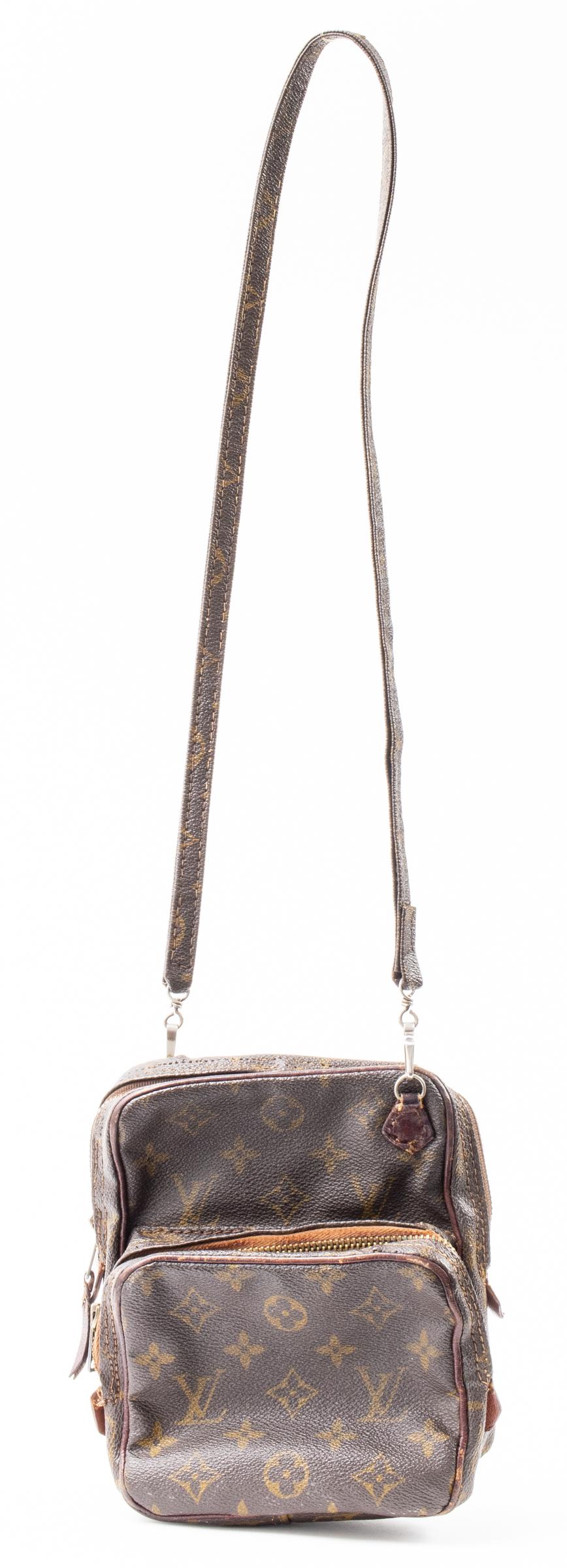 Brown Coated Canvas Camera Style Handbag: Brown coated canvas camera style handbag with spurious logo. 7.5" H x 6.5" W x 4" D. Wear.