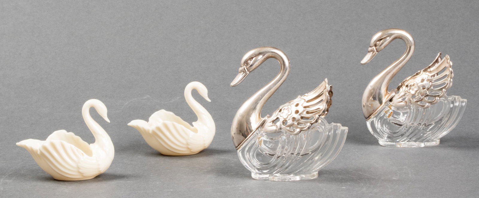 Italian Silver Plate and Lenox Porcelain Swans, 4: A pair of Lenox porcelain swans, maker's mark to underside and a pair of Italian silver plate and glass swans with movable wings, marked: "Italy" on neck. Glass and silver plate 3.50" H.
