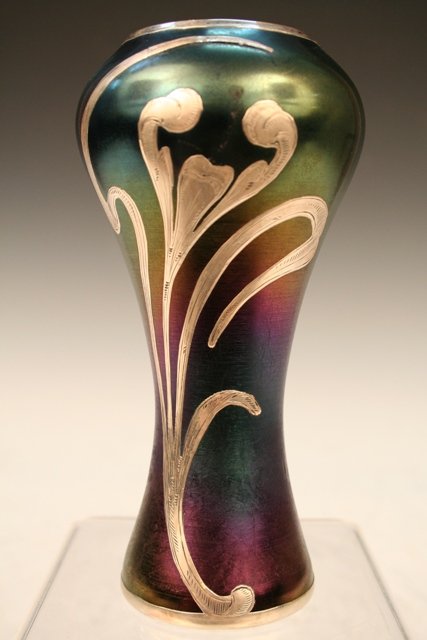 Austrian Loetz Glass Vase w/ Silver Overlay: Art Nouveau-era multi-colored vase decorated with a design in silver overlay, Loetz glass, Austria, ca. late nineteenth or early twentieth century. Dimensions: 6"H x 3" diameter