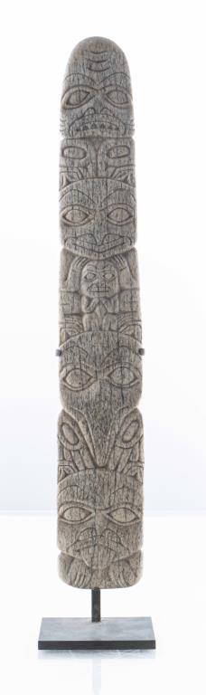 Northwest Coast Carved Bone Totem Pole on Stand: Pacific Northwest Coast carved bone totem depicting a stack of masks, on black metal display stand. Overall 16.25" H; totem 14.75" H.