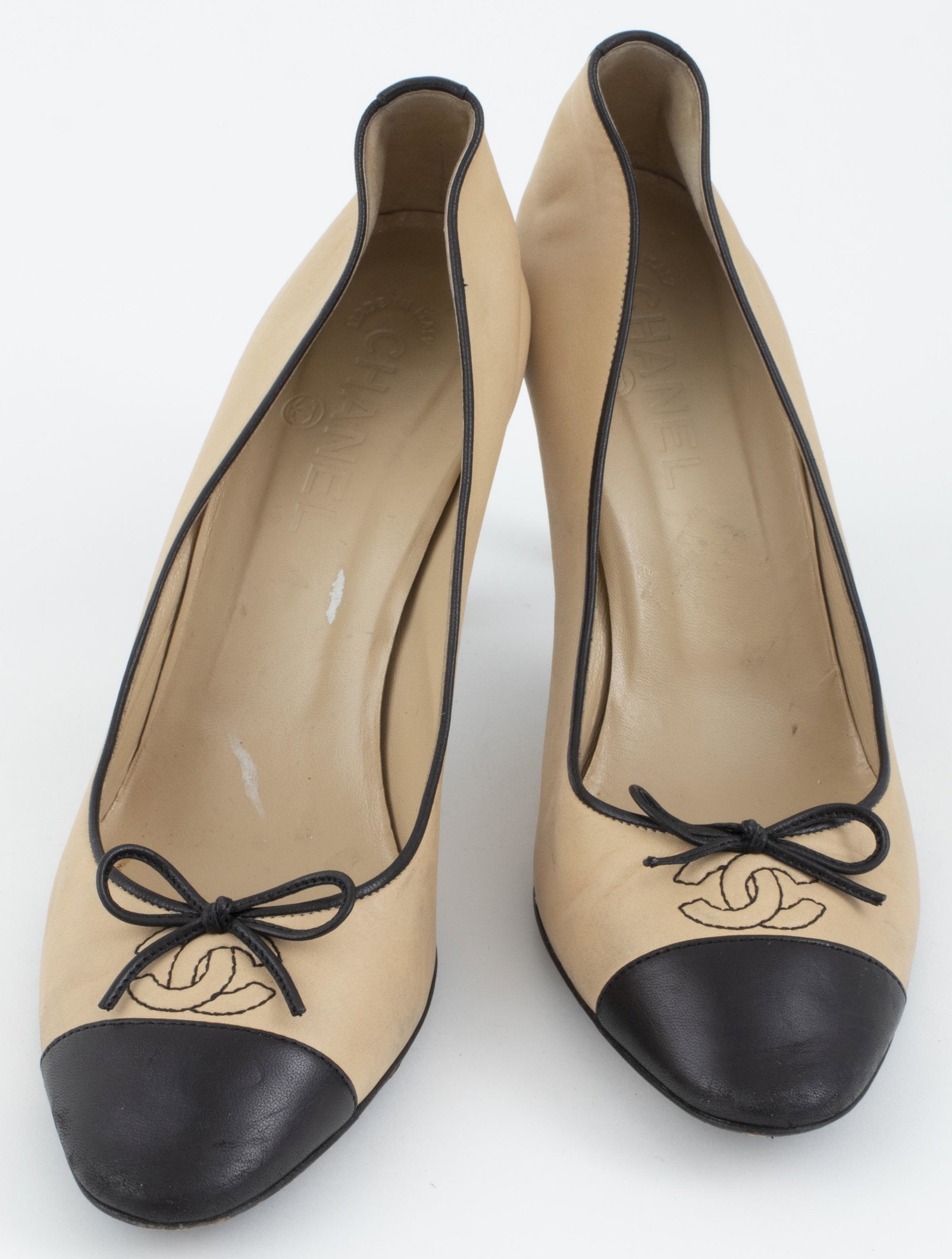 Chanel Black And Tan Leather Shoes, Sz. 39.5: Chanel high heel shoes in classic black and tan leather, the toes with stitched interlocking CC logo and bow detail, insoles and under soles marked "Chanel", marked size 39.5 and "Made in Italy". Heel