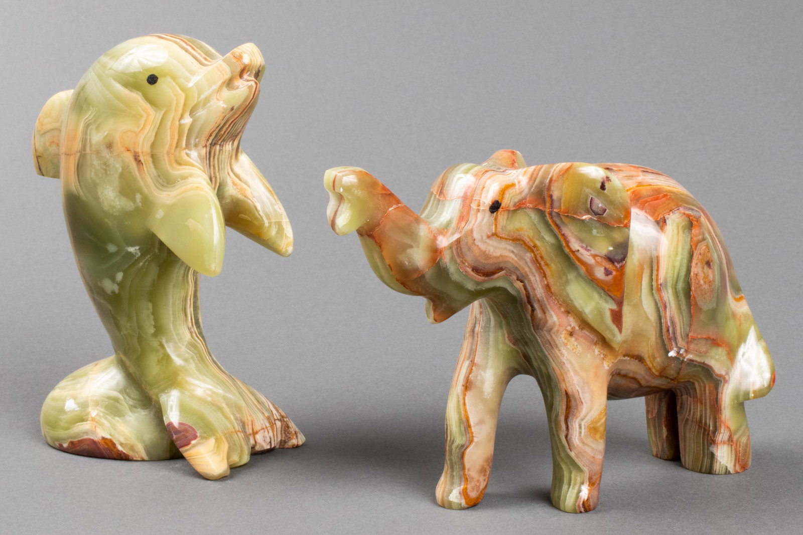 Carved Onyx Dolphin & Elephant Sculptures, 2: Two carved green onyx sculptures, one depicting an elephant, the other a dolphin. Dolphin: 6" H x 4" L x 2.25" W.