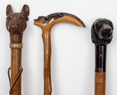 Assorted Carved Animal Figural Walking Sticks, 3: Assortment of three carved wood walking sticks / canes, one with spaniel dog handle and horn detail to shaft, one with bulldog pommel, and one with carved alligator to handle. Largest: 36.25" L.