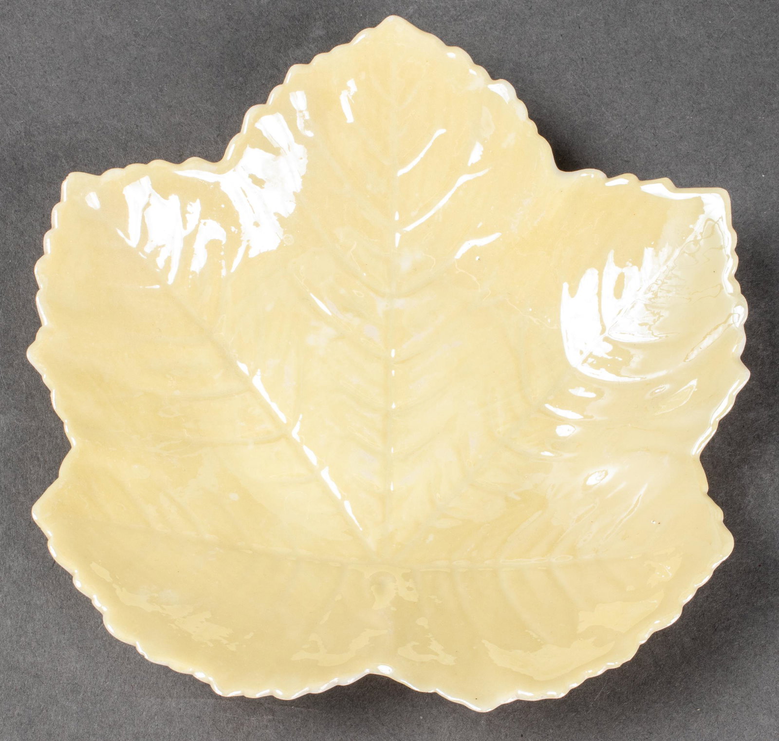 Belleek Maple Leaf Form Porcelain Tray: Glazed porcelain maple leaf trinket tray. Maker's mark to underside. 1" H x 5.75" W x 5.75" D