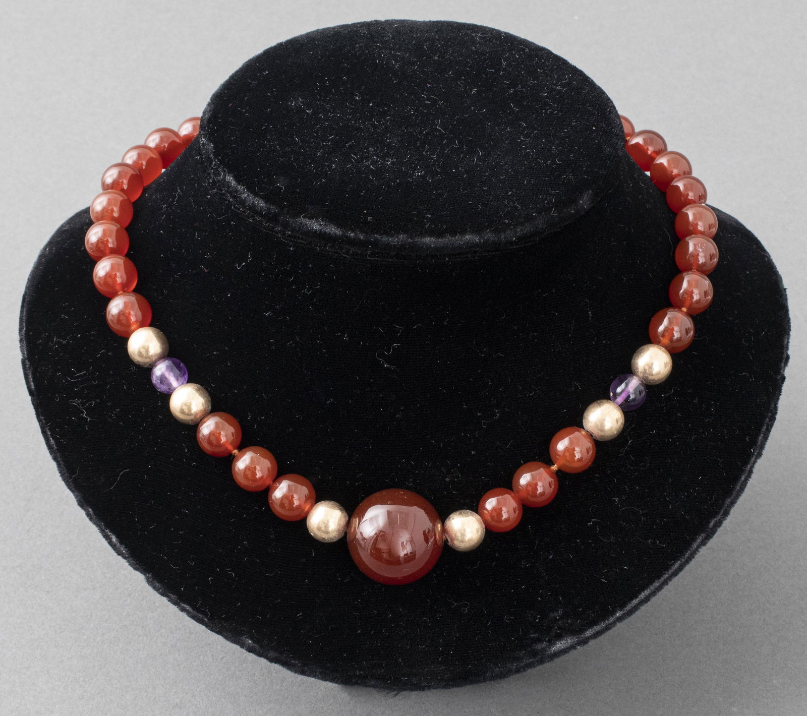 Carnelian, Amethyst, & Gold-Tone Bead Necklace: Carnelian bead collar necklace with amethyst and gold-tone bead accents, and a large central carnelian stone, the gold-fill clasp marked "14/20 G." 15.5" L.
