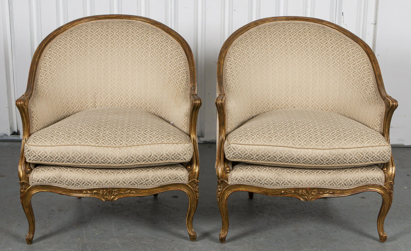 Louis XV Style Giltwood Bergères, Pair: Pair of Louis XV style giltwood bergères, 20th century, the carved framed raised above four cabriole legs. 33” H x 29.25” W x 29” D.