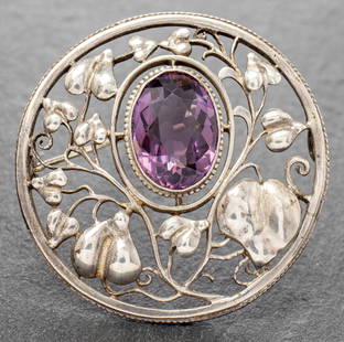 Theodor Fahrner Silver Amethyst Floriform Brooch: Antique Theodor Fahrner sterling silver amethyst floriform filigree round brooch / pin, bezel-set with one approx: 17 mm x 12 mm oval faceted-cut amethyst, marked: "TF 935." 1.87" L x 1.87" W x 0.56"