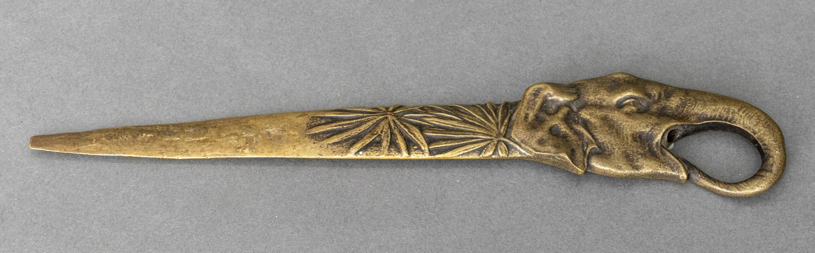 Brass Elephant Envelope Opener: Brass envelope opener with palms and an elephant head at the base of the handle. 9.25" L x 2" W.