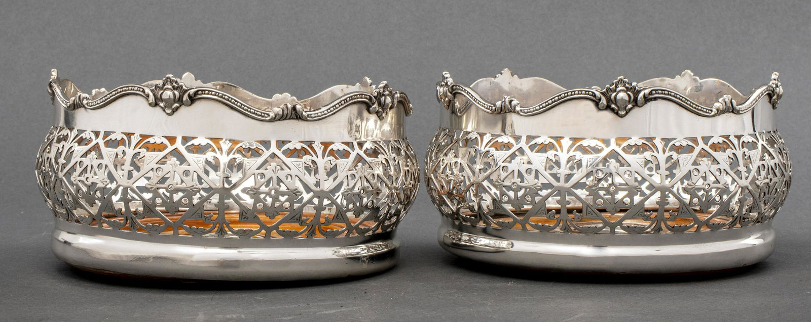 Silver-Plate and Wood Wine Coasters, Pair: Pair of pierced silver-plate and wood wine coasters, likely Sheffield. 3.25" H x 6" diameter.