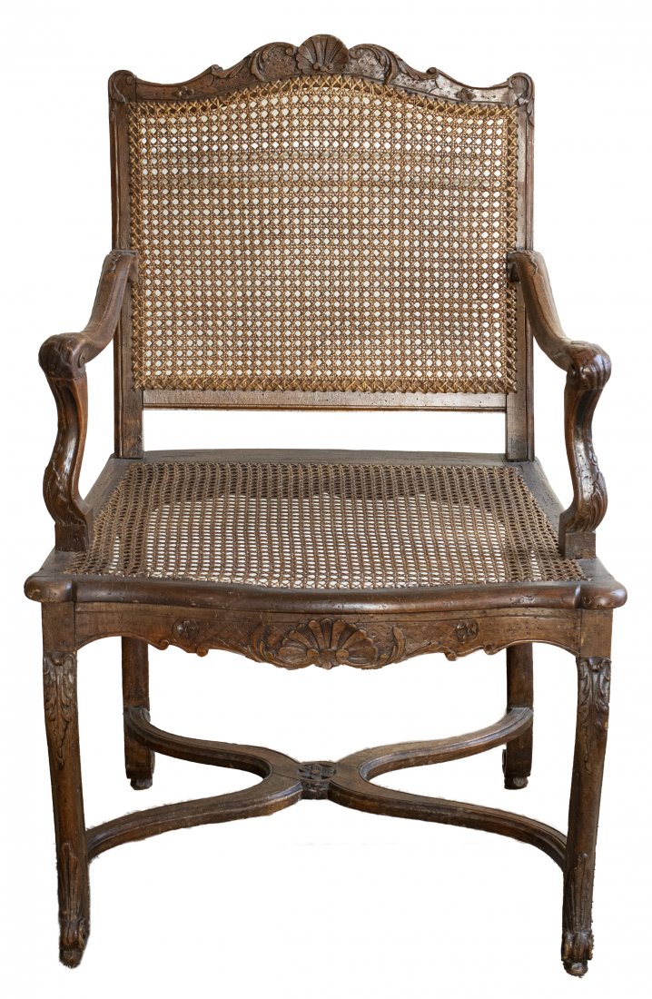 Regence Caned Fauteuil Armchair: Regence caned fauteuil, first quarter 18th century, the carved frame with acanthus and scrolling details, raised on cabriole legs. 38.5" H x 25.5" W x 22" D. Provenance: Removed from the Fifth Avenue 