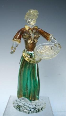 Italian Murano Art Glass Figurine Sculpture: Murano glass art figurine of woman with basket; internally decorated with green and brown core overlaid with heavy gold leaf, Italy; unmarked. Dimensions: 10"L x 5"W x 3-3/4"D