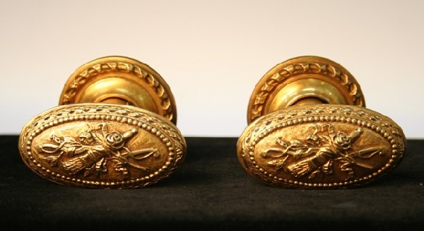 Lot of Gold-Plated Doorknobs & Holder P.E. Guerin: Lot including two heavily-chased gold-plated doorknobs including backplates with antique-gold finish, a Nouveau-style gold-plated doorknob with back plate featuring a flying cupid figure on the handle