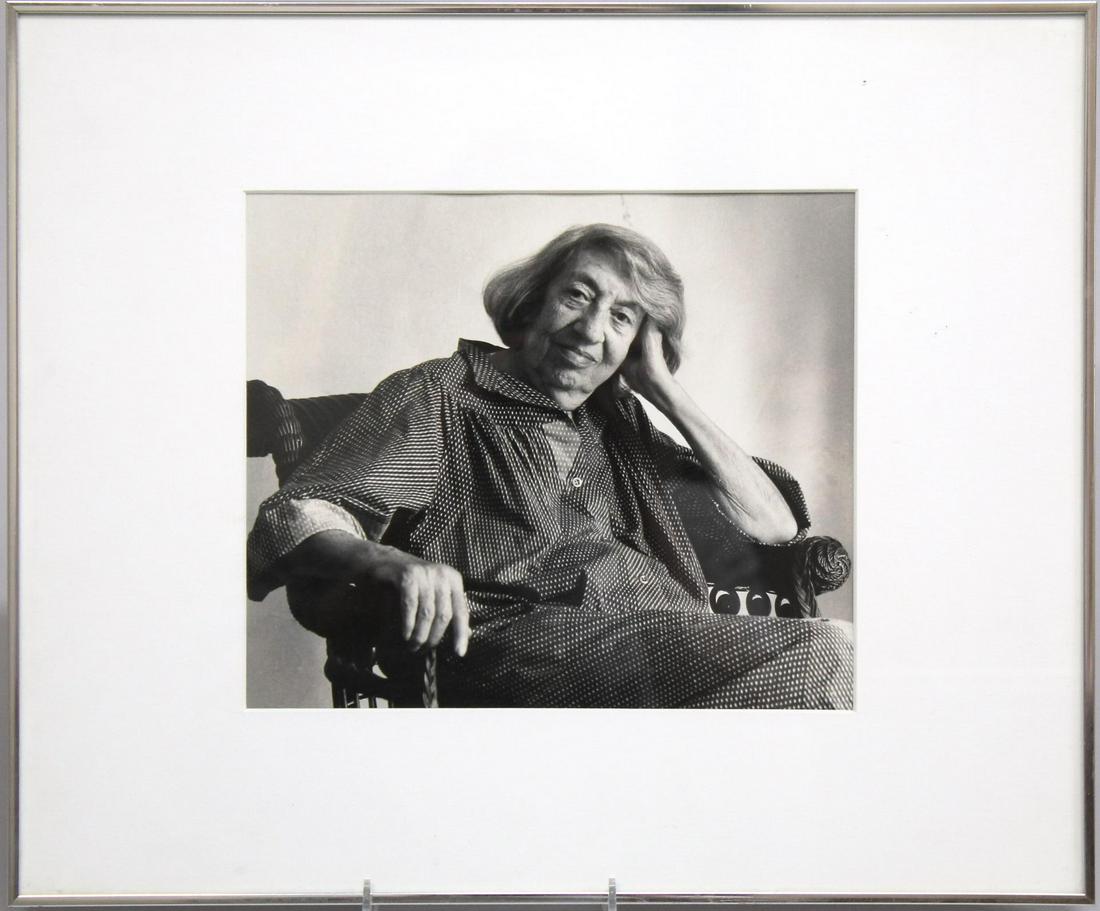 Portrait of Lee Krasner, B/W Photograph: Black and white photograph portrait of Lee Krasner, the elderly wife of Jackson Pollack sitting thoughtfully in a wicker chair. Image: 8" H X 9" W ; frame: 13.75" X 16" W.