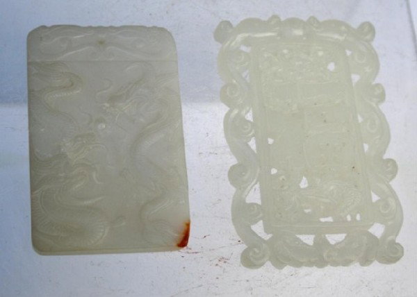 Lot of Two Chinese Carved White Jade Pendants: Two rectangular pendants with small holes for a string at the tops, one features two dragons carved in low relief on one side and the other pictures a bird and dear in the central panel with a perfora