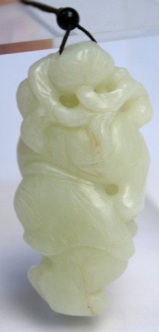 Chinese Carved Jade Pendant of Figure: Small carved pendant of figure and foliage, perforated at top, and attached to dark brown string, jade, China; unmarked. Dimensions: Jade approximately 2-3/4"L x 1-3/8"W x 1-1/8"D