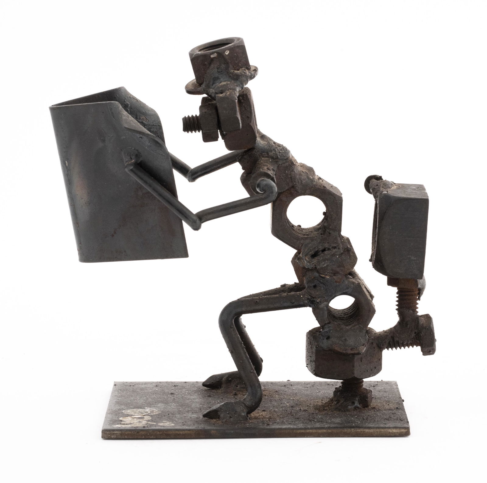 Signed Illegibly Nuts & Bolts Sculpture: Nuts and Bolts sculpture of man sitting on toilet reading a newspaper, signed illegibly. 5" H x 4" W x 3" D. Provenance: Property from the estate of Arnold Neustadter, inventor of the Rolodex.