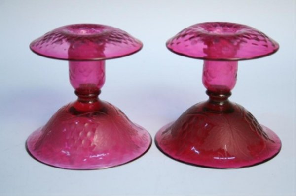 Pairpoint Glass Rosaria Cranberry Candlesticks: Pair of candlestick holders with grape pattern in cranberry color, made by Pairpoint Glass, United States, circa 1925; unmarked. Dimensions: Each approximately 4"H x 4-1/4" diameter