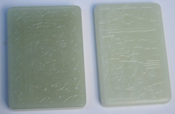 Lot of 2 Chinese Carved White Jade Pendants: Two rectangular pendants with small holes for string at the tops, one featuring a landscape scene carved in low relief on one side and calligraphy on the reverse. The other pendant features a central 