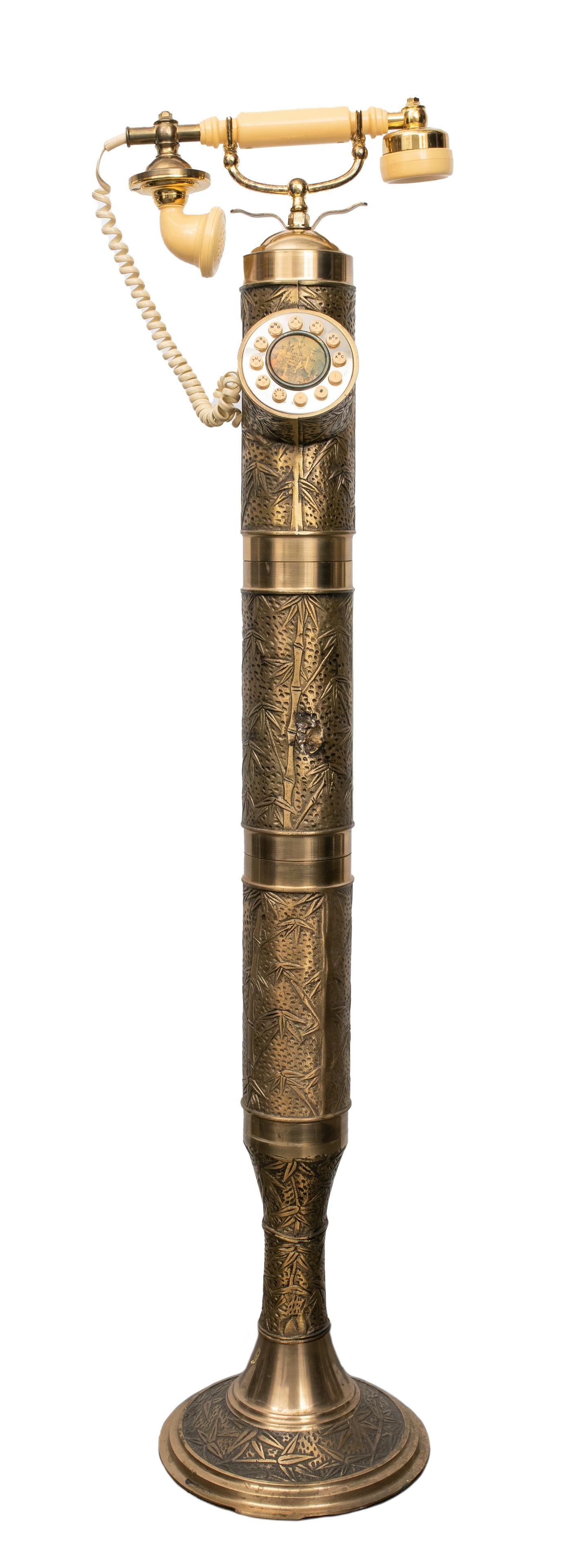 Vintage Japonesque Motif Standing Telephone: Vintage standing telephone made of brass decorated with Japonesque bamboo design, the dial plate includes an image of Neuschwanstein Castle, upon a carved circular base. 42" H x 10.5" W x 8.75" diamet