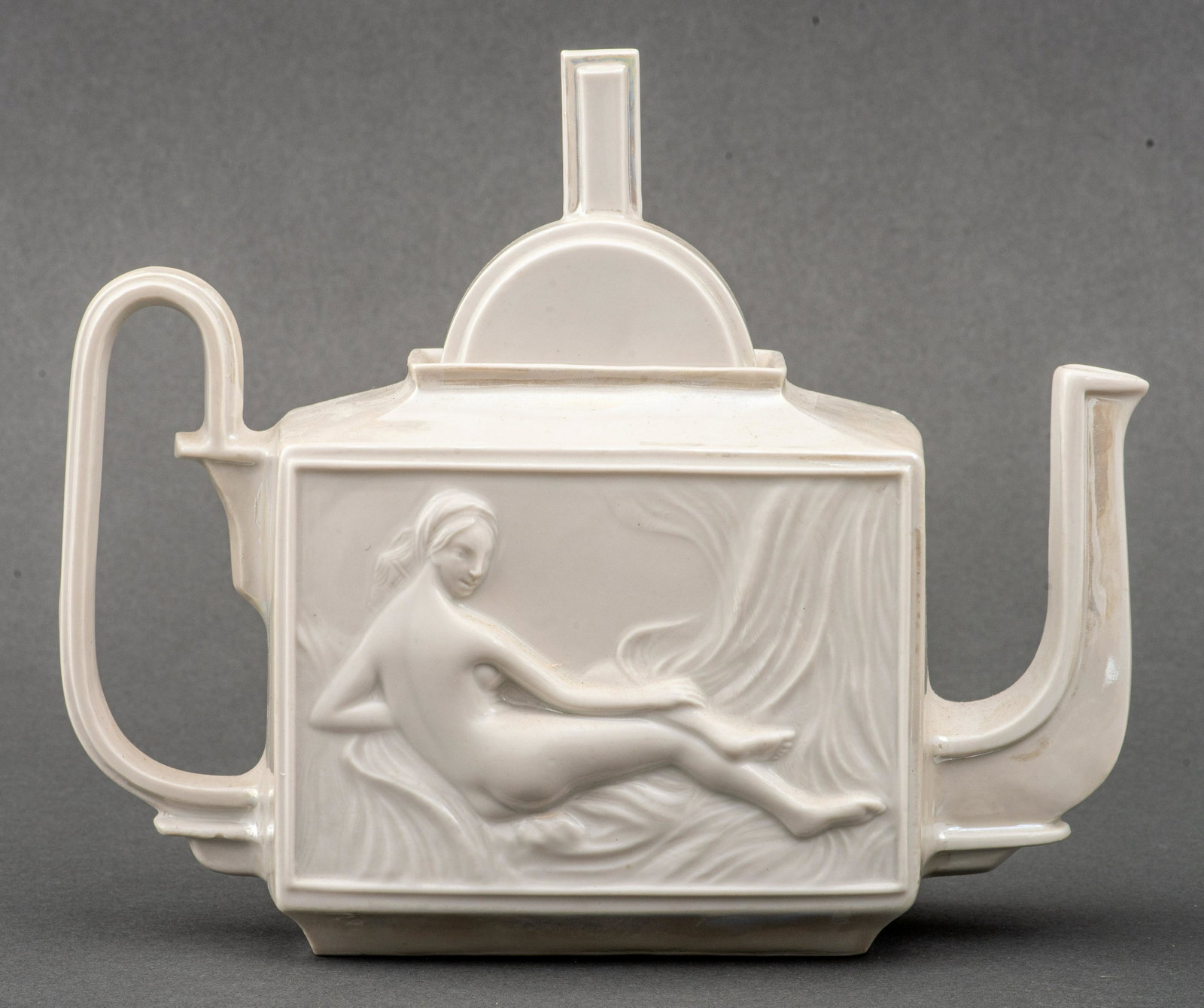 Art Deco Revival Iridescent Glazed Ceramic Teapot: Art Deco revival porcelain teapot decorated with figural reliefs of reclining nude women, one of the Grande Odalisque by Ingres, the other similar to Maya Desnuda by Goya, marked, 8.25" H x 9.5" L x 3