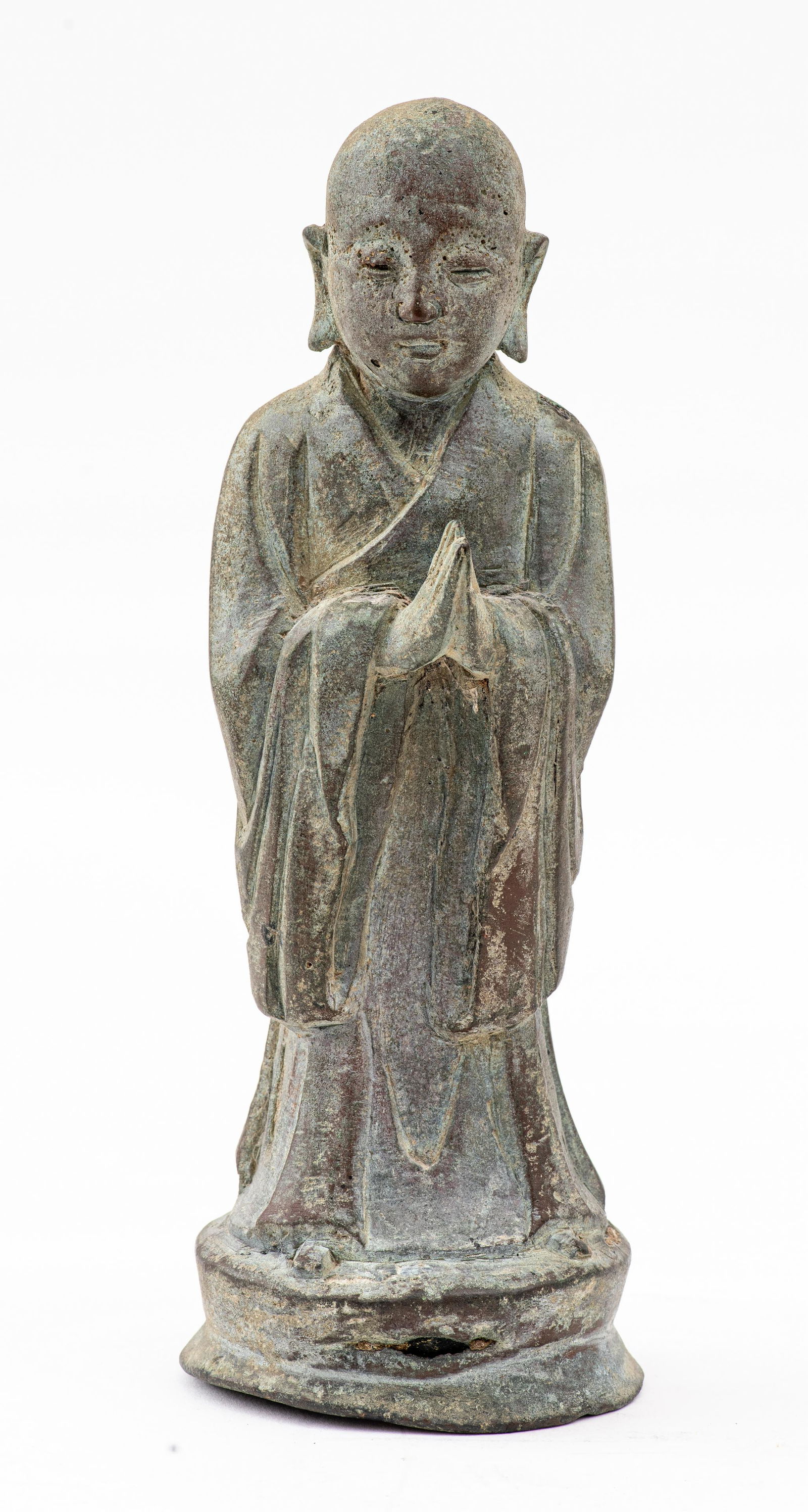 Chinese Bronze Sculpture of a Monk: Antique Chinese bronze sculpture depicting a hairless monk with hand in prayer position, upon a circular base. 9.5" H x 3.5" diameter.