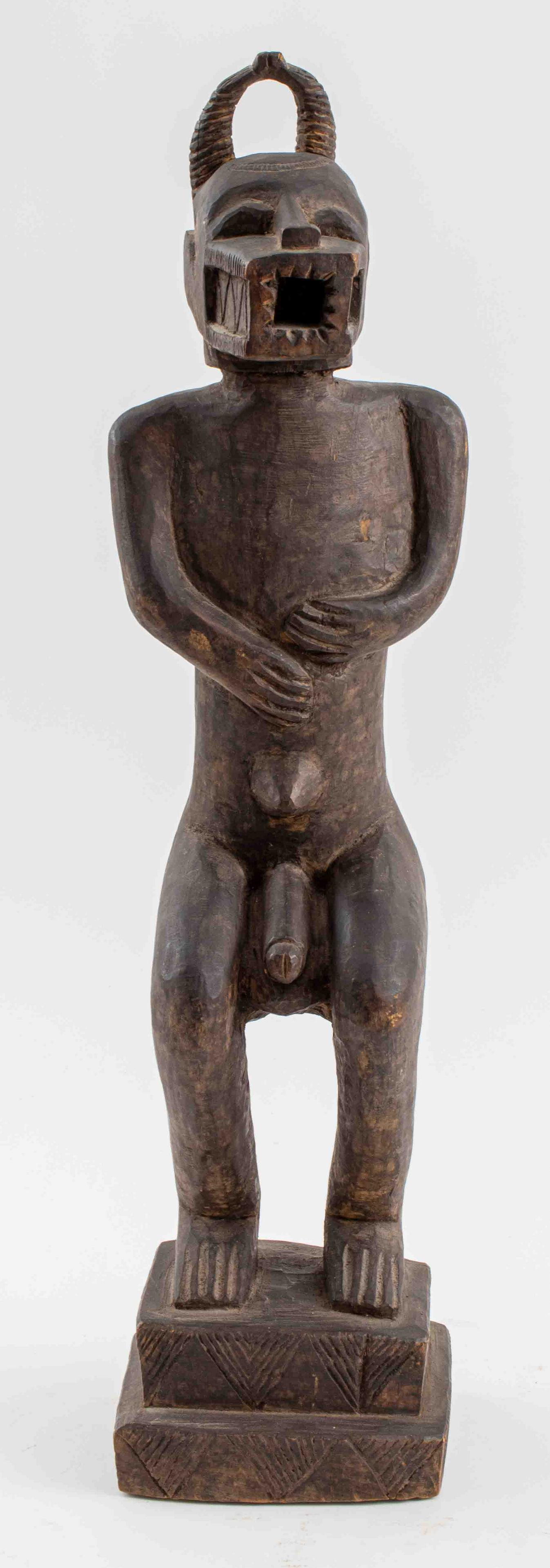 Igbo Wooden Ikenga Figure with Ram Horns: African, Igbo people of Nigeria, carved hardwood ikenga figure with horns and protruding mouth, the male nude is probably wearing a ceremonial mask, the legs bent at the knees and all upon a two-tiere