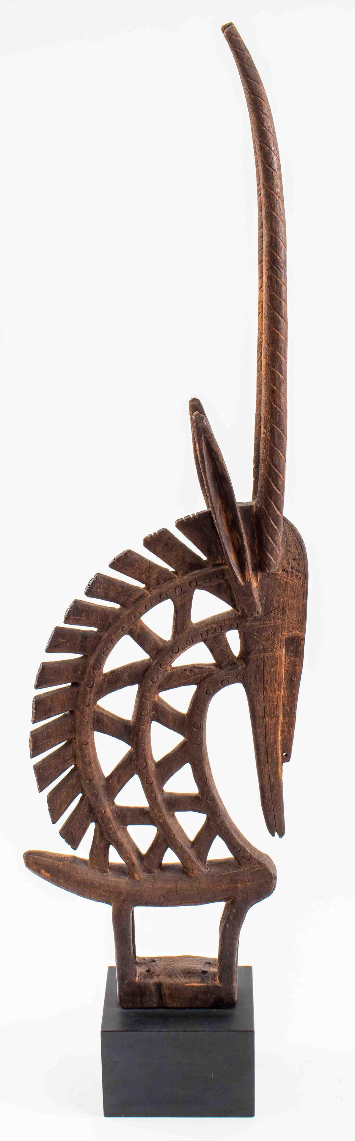 Bambara Wooden Antelope Chiwara Headdress: African, Bambara people of Mali, carved hardwood antelope / chiwara vertical headdress, with incised geometric motif in the Segu style, mounted on a black rectangular base. 40" H x 11" W x 5.25" D wit