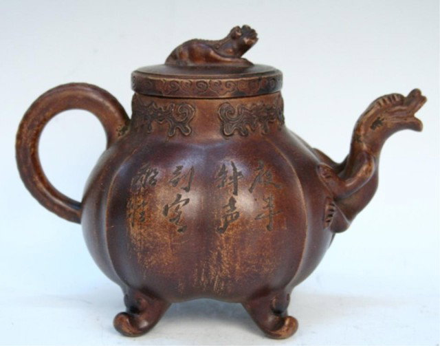 Chinese Yixing Clay Melon-Shaped Teapot: Melon-shaped teapot with four feet and spout shaped like a chilong (hornless dragon), Yixing ceramic, China; marked. Dimensions: Approximately 5-1/2"H x 8"W x 4-1/2"D