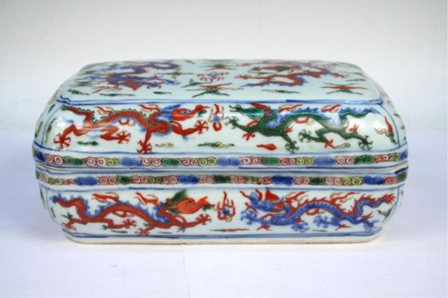 Ming Chinese Wanli Wucai Porcelain Lidded Box: Wanli wucai lidded box with dragon motif in underglaze blue-and-white and overglaze red, yellow, and green, porcelain, China, Ming Dynasty (1368-1644); marked on bottom. Dimensions: 4"H x 9-1/2"L x 5-