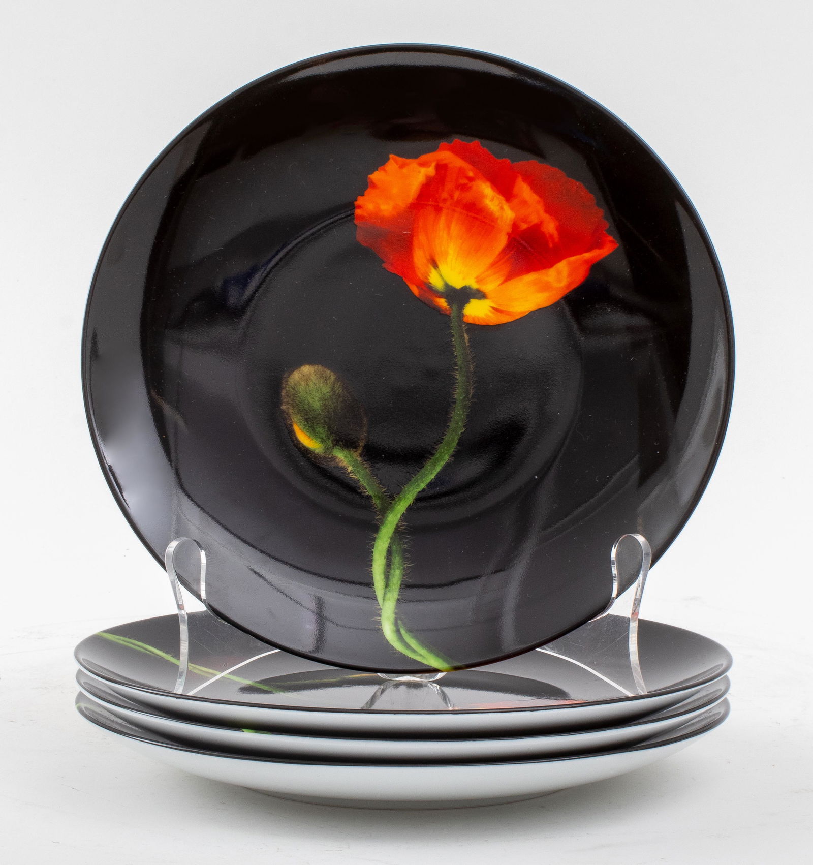 Robert Mapplethorpe for Limoges "Poppy" Plates, 4: Set of four Robert Mapplethorpe (American, 1946-1989) by Ligne Blanche for Limoges porcelain plates in the "Poppy" design on a black ground, all marked to undersides. 8.25" diameter.