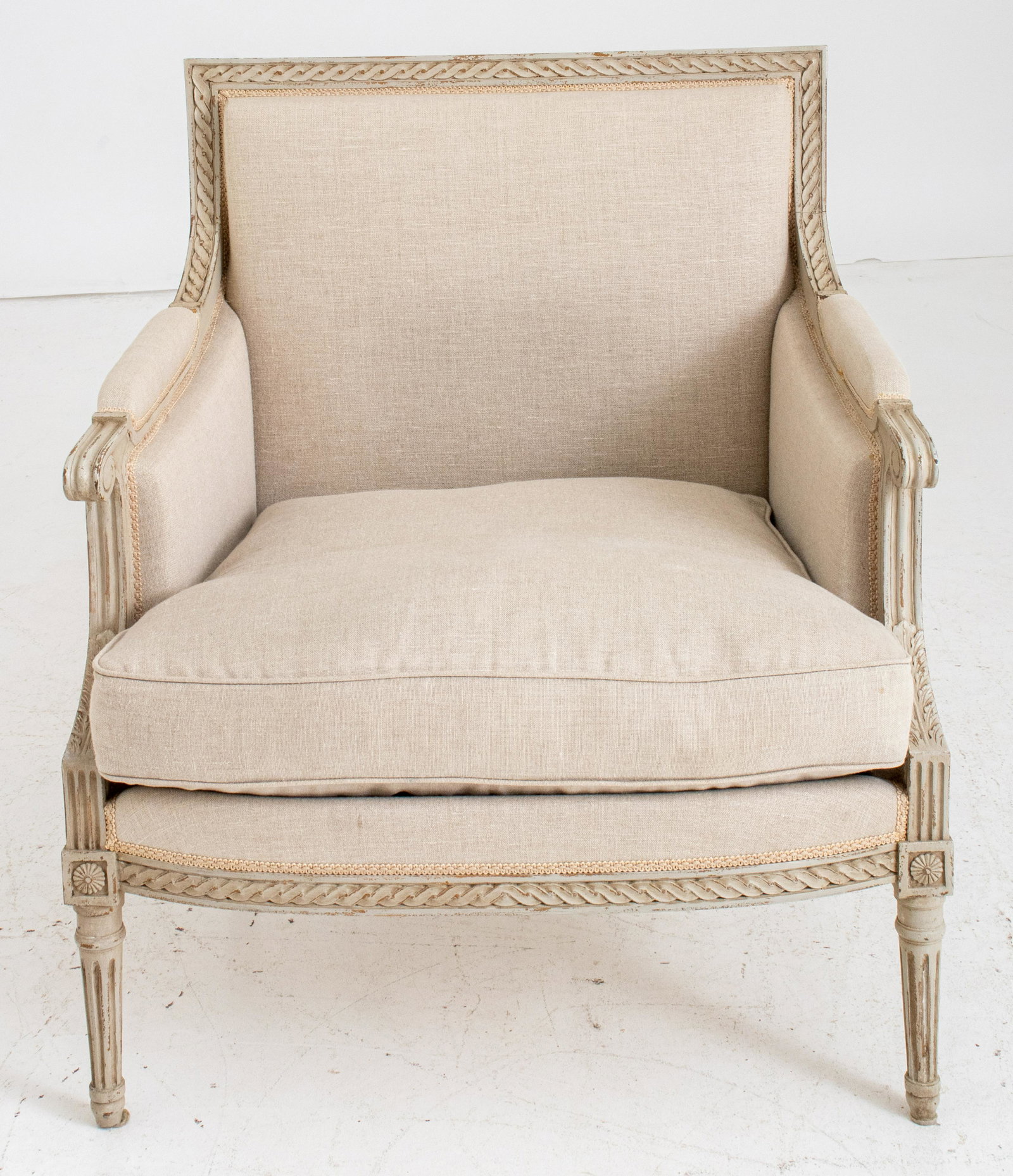 Louis XVI Style Bergere Armchair: Louis XVI style bergere armchair with semi-distressed carved wood and upholstery. 35.5" H x 32" W x 27" D. Seat 19" H.