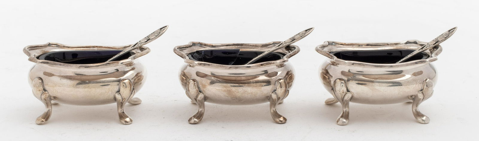 Cartier Cobalt Glass Salt Cellars & Spoons, 3: English, Birmingham, cobalt glass lined salt cellars manufactured by William Suckling, Ltd., made for Cartier, stamped with English hallmarks and marked "Cartier / Made in England," together with thre