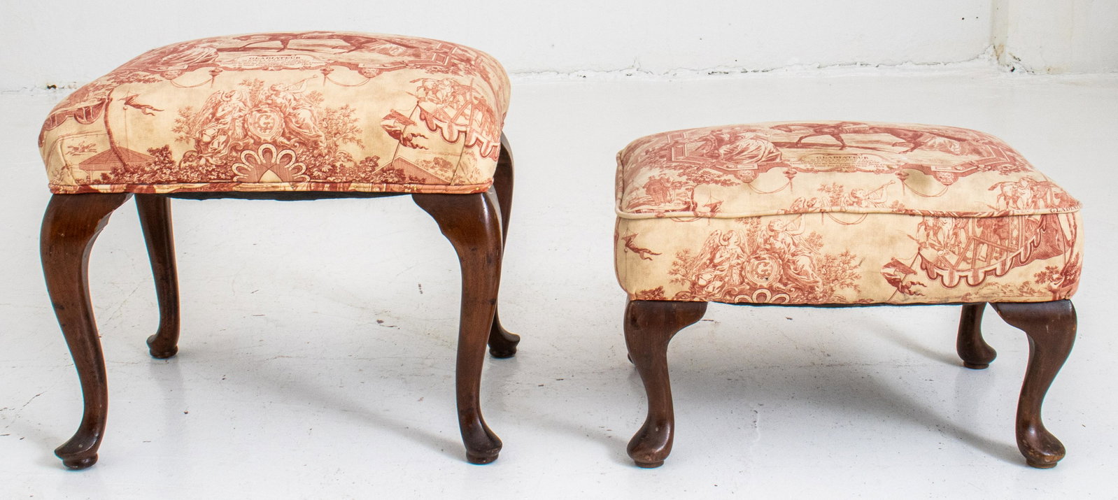Queen Anne Style Upholstered Stools, 2: Queen Anne style benches,two, each with rectangular seats above cabriole legs on pad feet, each upholstered in red and white 'toile de jouy' printed fabric, "Gladiateur." 18" H x 21" W x 17" D (the la