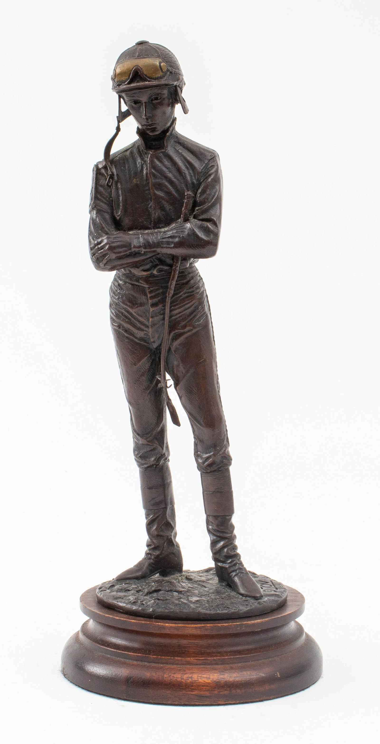 Signed Bronze Sculpture of a Standing Jockey: Patinated bronze sculpture depicting a standing jockey, marked on base and dated 1961 to underside, mounted upon a circular wooden base. 9.25" H x 4" diameter.