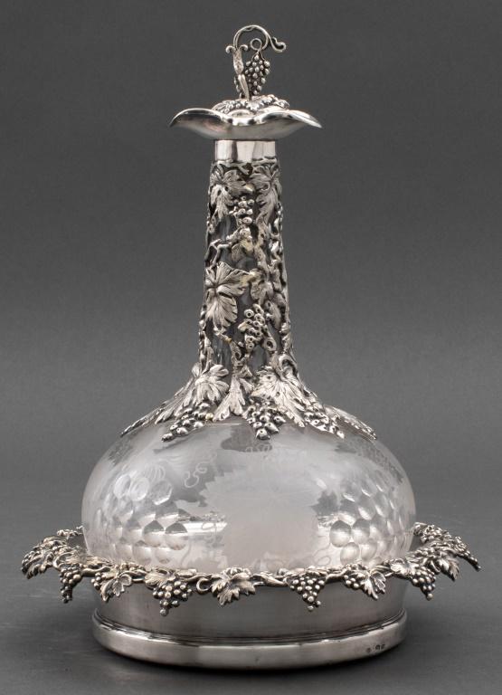 Victorian Magnetic-Plate Mounted Decanter Set: Victorian magnetic plate mounted wheel-engraved glass decanter set, with marks for Thomas Prime, London, circa 1849-1851, and comprising a decanter and stopper (cork missing) within a wine coaster ens