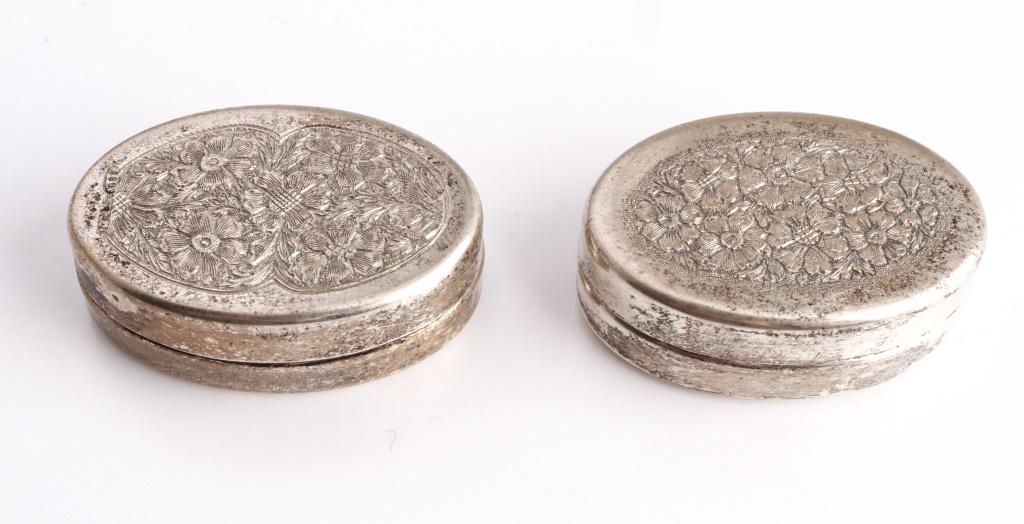 Silver Engraved Floral Motif Pill Boxes Group of 2: Group of two silver engraved floral motif pill boxes. 1.5" W x 1" D. Approx 0.83 ozt.