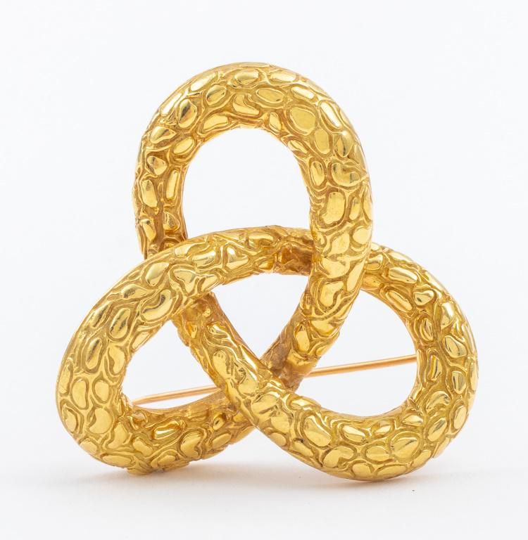 18K Yellow Gold Gordian Knot Pin/Brooch: A pin / brooch made in 18K yellow gold, carved on the front side and brightly polished on all surfaced, designed in the shape of a "Gordian" knot, worn with a pinstem and joint catch, marked" CJ 18K".